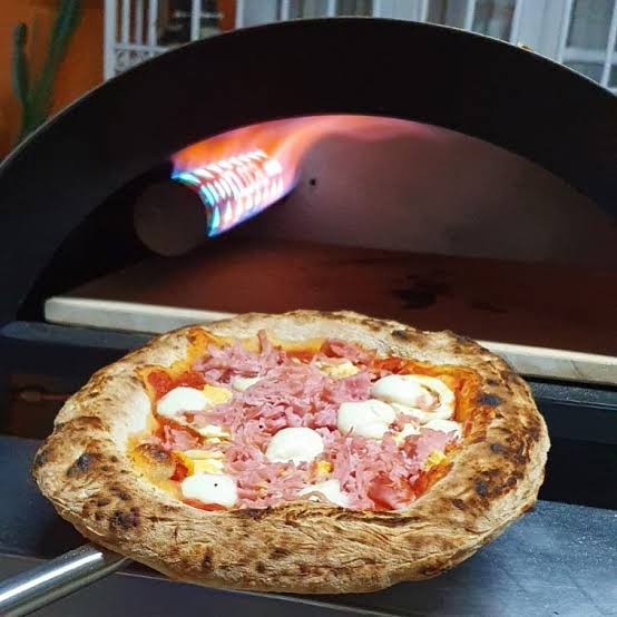 Pizza artesanal sendo preparada em alta temperatura
